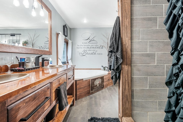 bathroom featuring tiled tub, vanity, and tile patterned floors