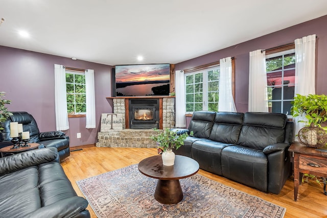 living room with hardwood / wood-style flooring, a fireplace, and a healthy amount of sunlight