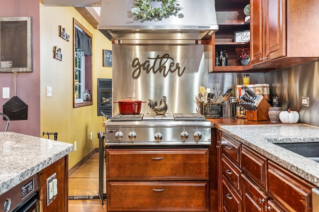 kitchen with stainless steel gas stovetop, light hardwood / wood-style floors, light stone countertops, and exhaust hood