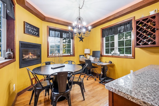 dining room featuring light hardwood / wood-style flooring, ornamental molding, and an inviting chandelier