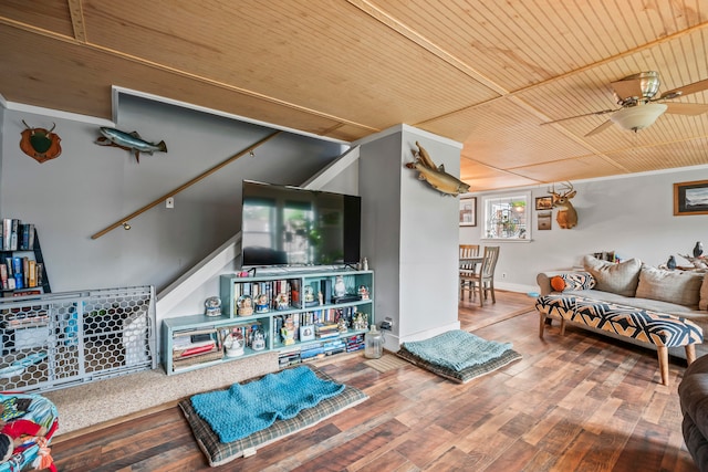 living room with wood-type flooring, wood ceiling, ornamental molding, and ceiling fan