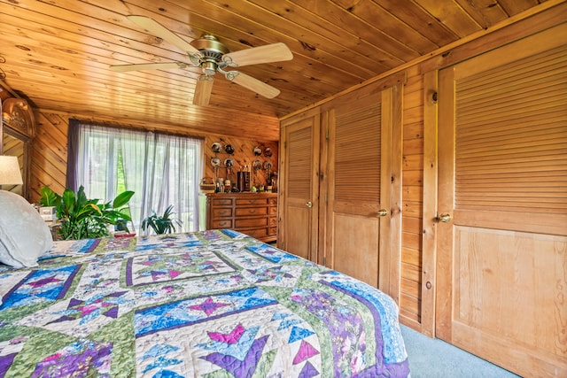 carpeted bedroom with ceiling fan, wooden walls, and wooden ceiling