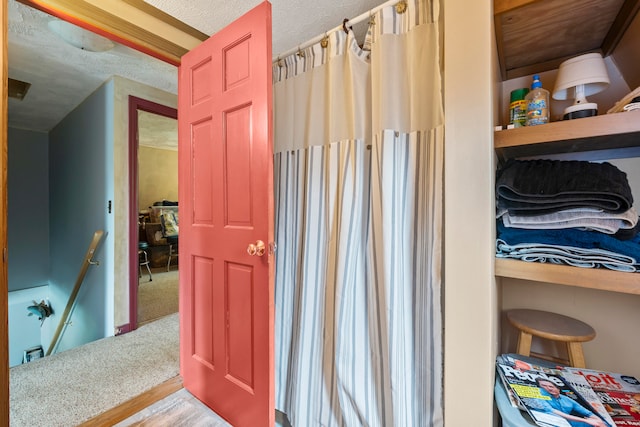 bathroom with wood-type flooring and a textured ceiling