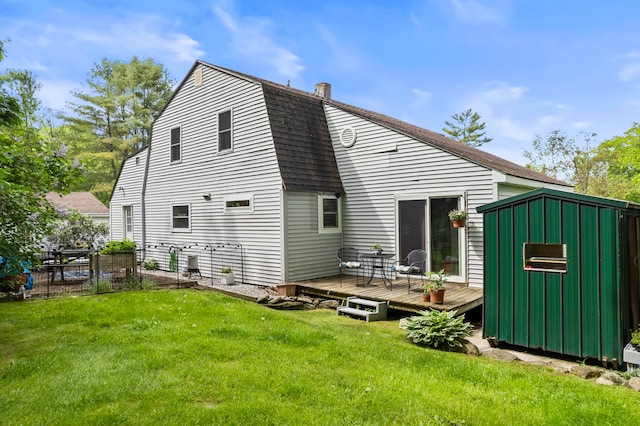 back of house featuring a storage shed, a yard, and a wooden deck