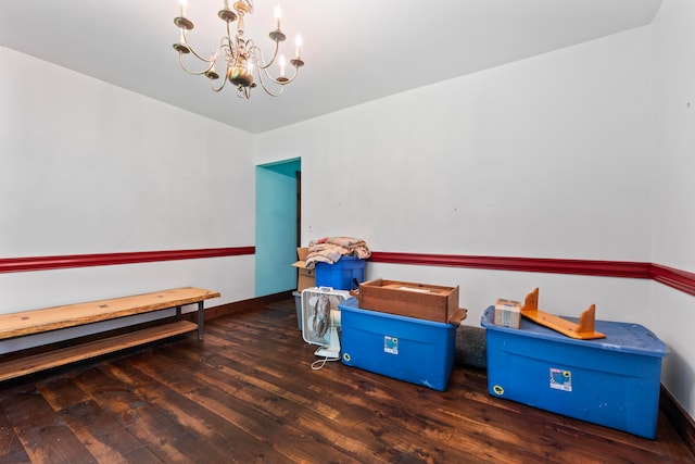 game room featuring dark wood-type flooring and a chandelier