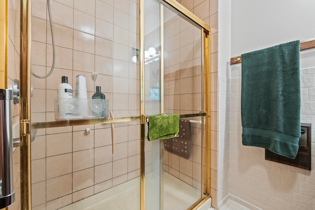 bathroom featuring tile walls and a shower with door