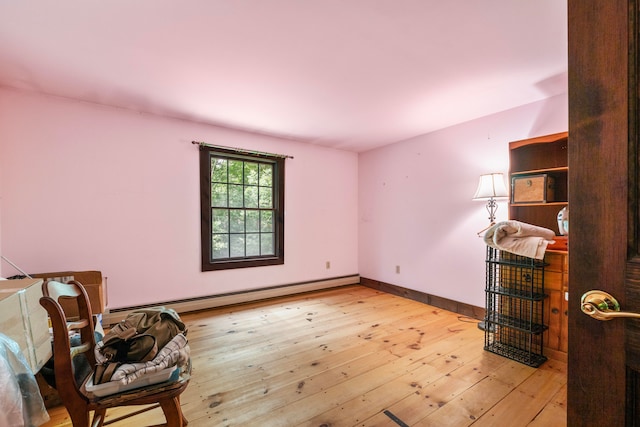 sitting room with light hardwood / wood-style flooring and a baseboard heating unit