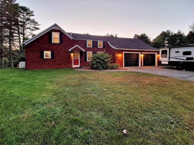 view of front of home with a garage and a lawn