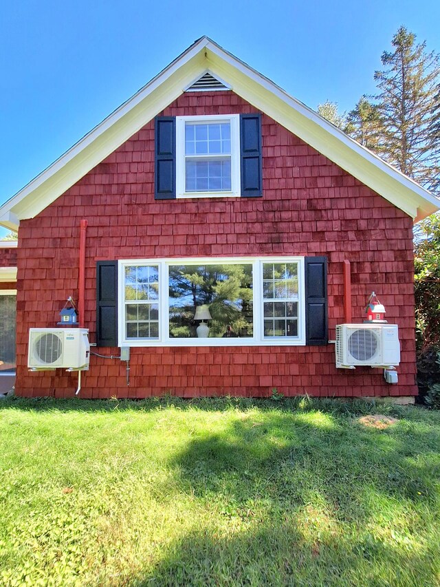 exterior space with ac unit and a yard