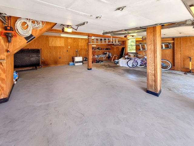 garage with a garage door opener and wood walls