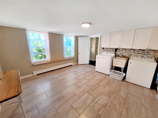 kitchen with white cabinetry, backsplash, separate washer and dryer, baseboard heating, and sink