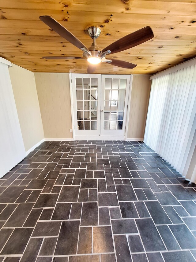 unfurnished living room with ceiling fan, wooden walls, and wood ceiling