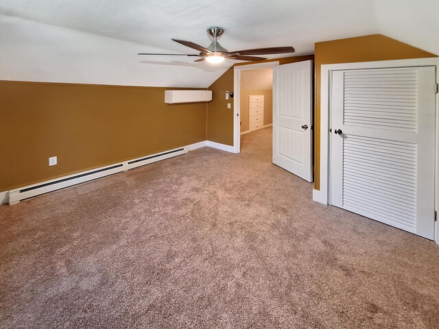 unfurnished bedroom featuring vaulted ceiling, a baseboard heating unit, carpet flooring, ceiling fan, and a wall mounted AC