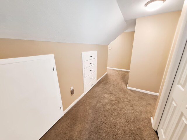 hallway with light carpet and vaulted ceiling