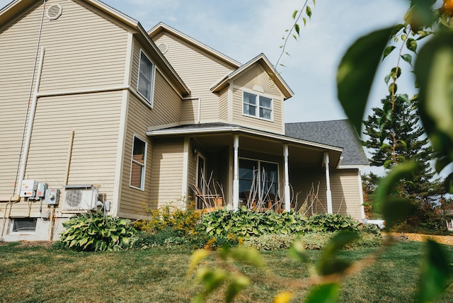 rear view of property featuring covered porch