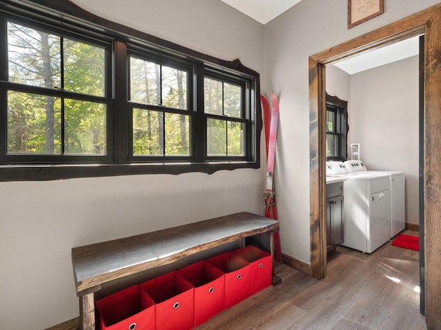 washroom with cabinets, a wealth of natural light, dark hardwood / wood-style floors, and separate washer and dryer