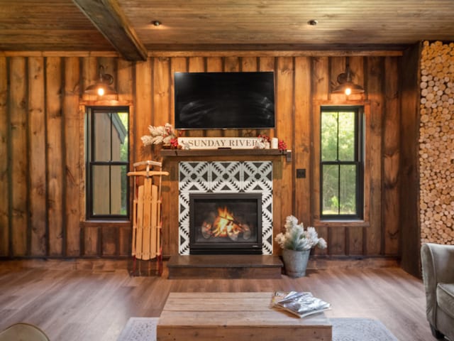 unfurnished living room with wood-type flooring, beamed ceiling, wood ceiling, and wood walls