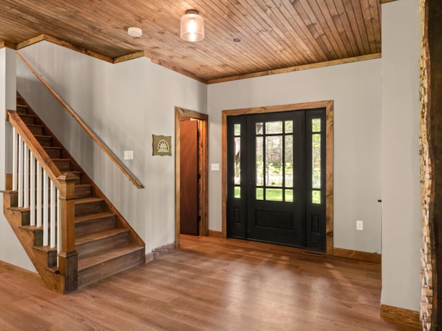 entrance foyer with hardwood / wood-style flooring, ornamental molding, and wooden ceiling