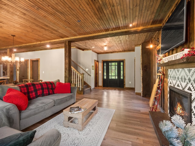 living room with wooden ceiling, a fireplace, an inviting chandelier, and hardwood / wood-style flooring