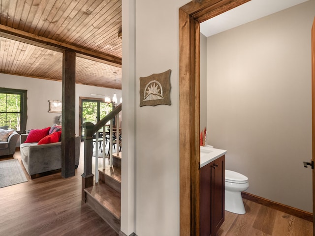 bathroom featuring vanity, wood ceiling, hardwood / wood-style flooring, an inviting chandelier, and toilet