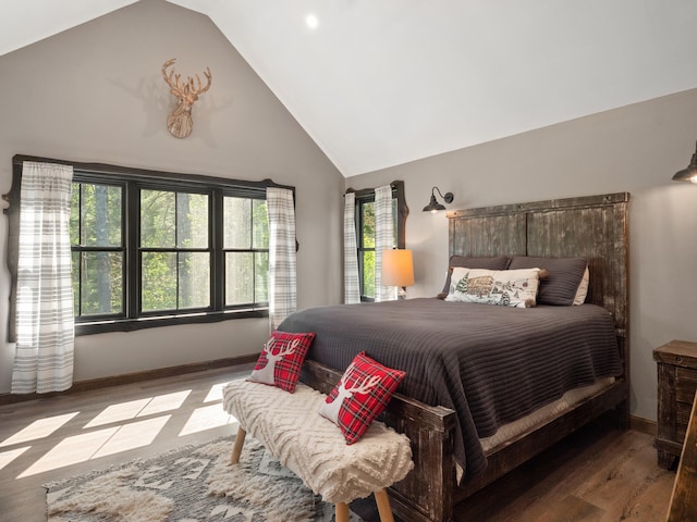 bedroom featuring high vaulted ceiling and hardwood / wood-style flooring