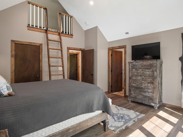 bedroom featuring high vaulted ceiling and dark hardwood / wood-style flooring