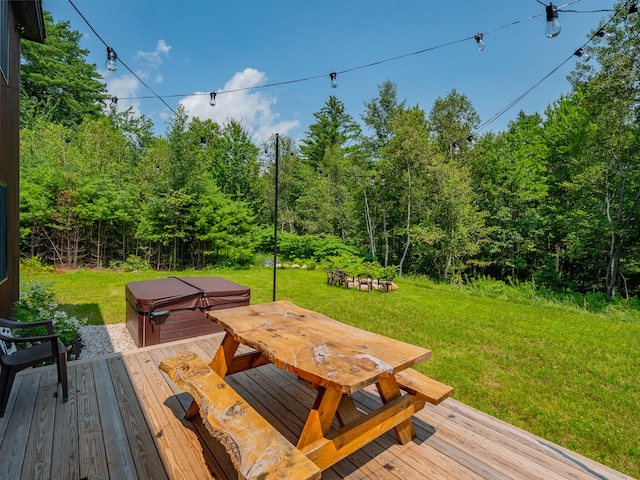 wooden terrace featuring a covered hot tub and a yard