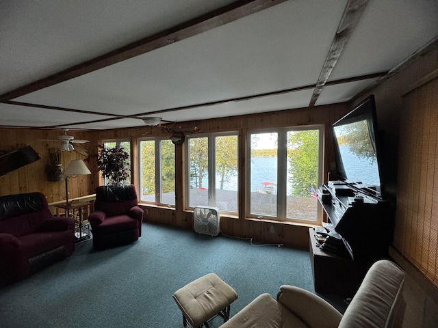 sunroom featuring ceiling fan and beamed ceiling