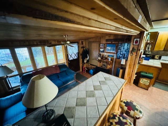 living room featuring vaulted ceiling, wooden walls, and ceiling fan