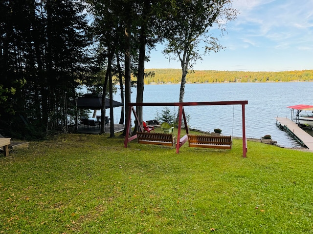 view of yard with a gazebo, a boat dock, and a water view