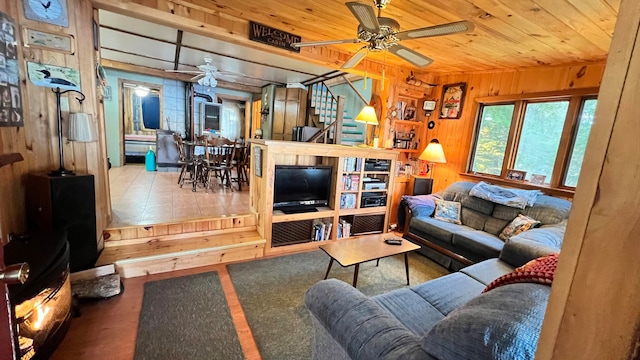 living room featuring wooden ceiling, wooden walls, and ceiling fan