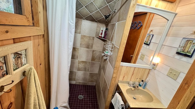 bathroom with wood walls, curtained shower, and vanity