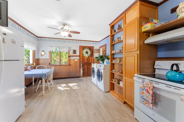 washroom featuring ornamental molding, wooden walls, ceiling fan, and washing machine and clothes dryer