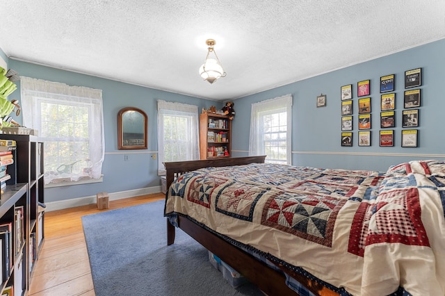 bedroom with a textured ceiling and light hardwood / wood-style floors