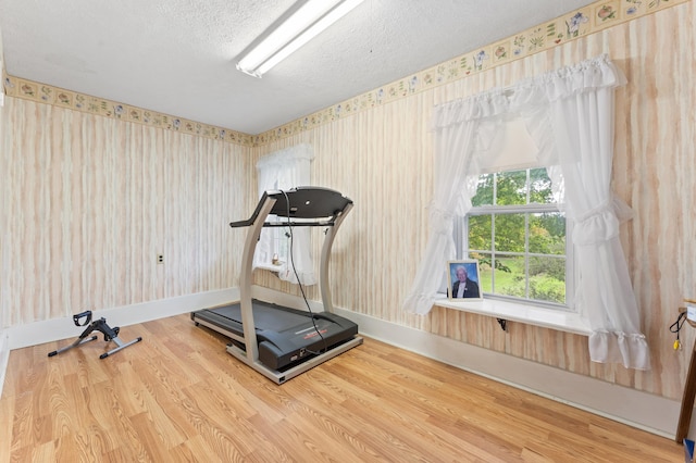 workout room featuring a textured ceiling and hardwood / wood-style flooring