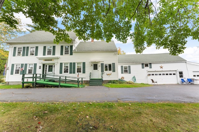 colonial home featuring a garage and a front yard