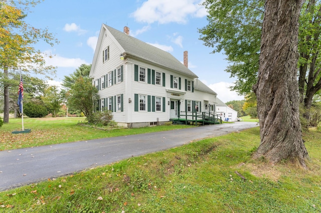 colonial home with a front lawn