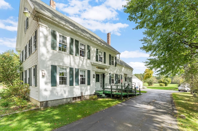 colonial inspired home featuring a front lawn