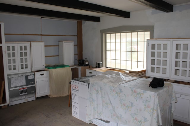 kitchen with beam ceiling and white cabinets