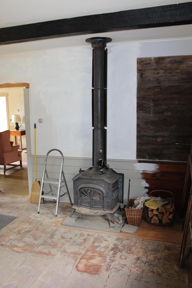 interior details with wooden walls, beamed ceiling, and a wood stove