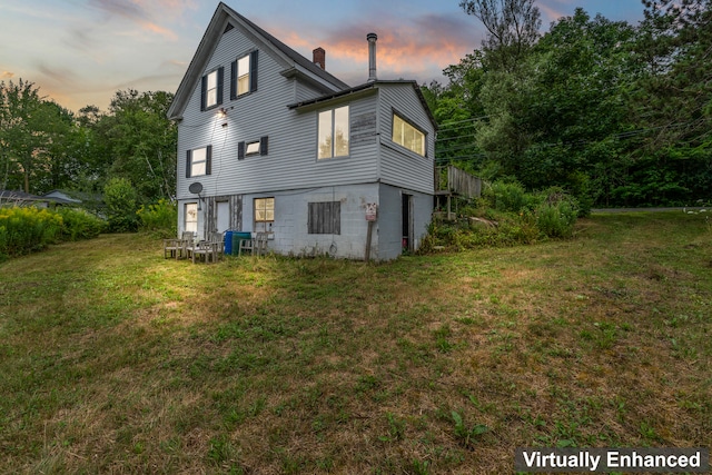 property exterior at dusk featuring a yard