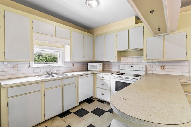 kitchen featuring white cabinets, sink, tasteful backsplash, and white appliances