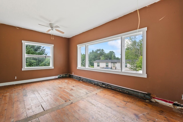 empty room featuring wood-type flooring, ceiling fan, and a wealth of natural light