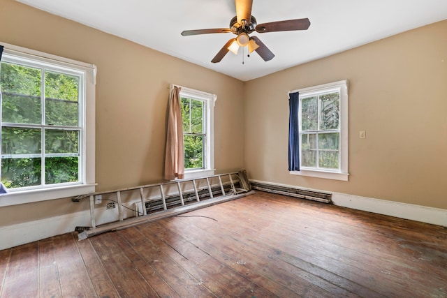 empty room with a wealth of natural light, ceiling fan, and hardwood / wood-style flooring