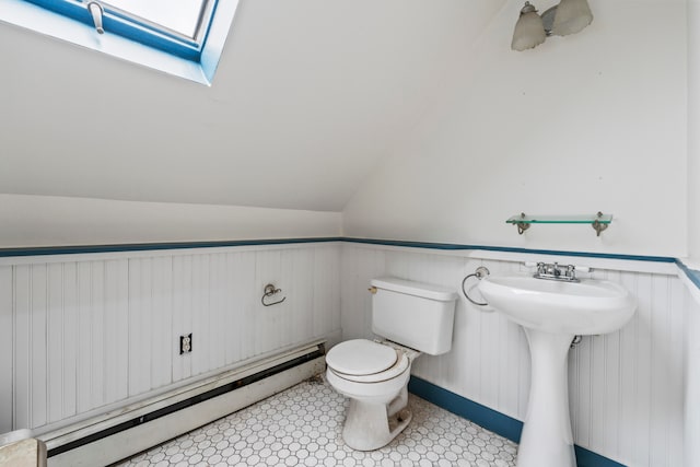 bathroom with baseboard heating, lofted ceiling with skylight, and toilet