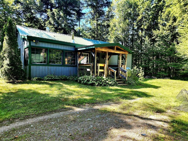 rear view of property featuring a yard