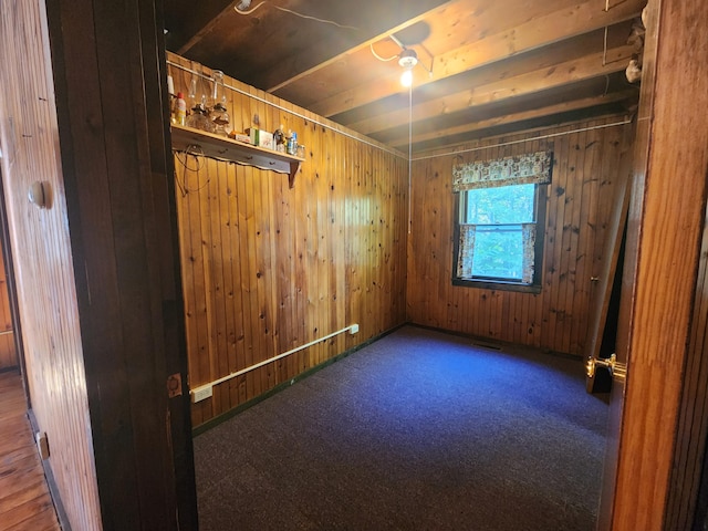 carpeted spare room with wood walls