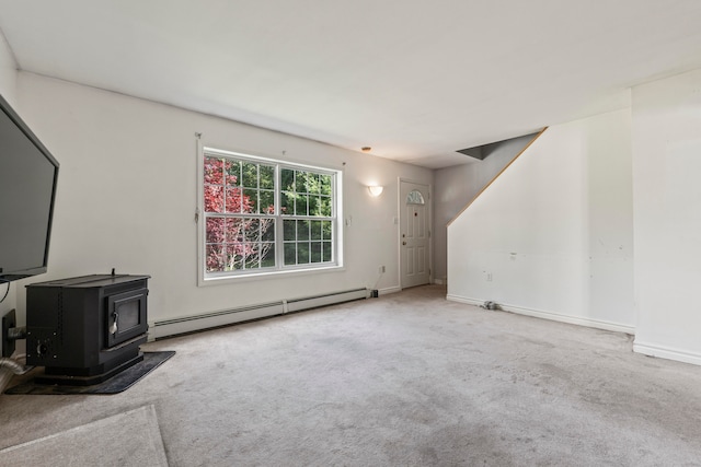 unfurnished living room featuring light colored carpet, a wood stove, and a baseboard heating unit