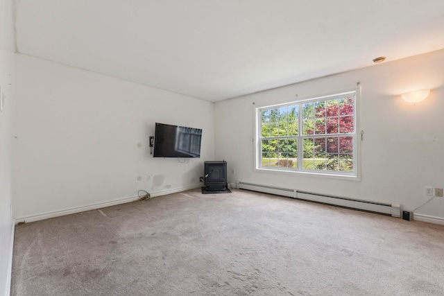 unfurnished living room featuring a baseboard radiator, a wood stove, and carpet flooring