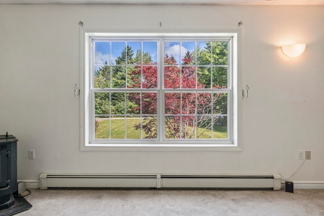 carpeted spare room with a healthy amount of sunlight, a baseboard heating unit, and a wood stove